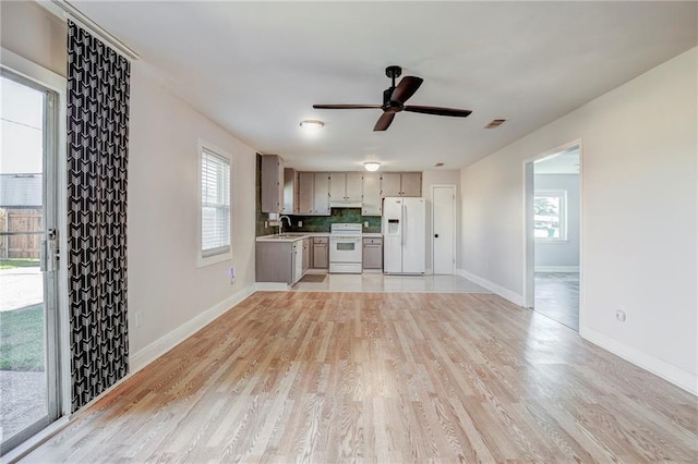 kitchen with white appliances, ceiling fan, sink, light hardwood / wood-style flooring, and tasteful backsplash