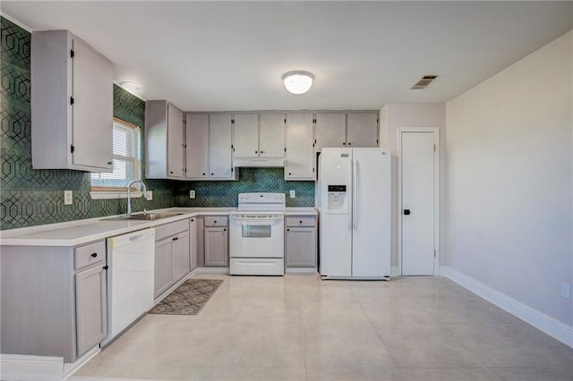 kitchen featuring sink, white appliances, tasteful backsplash, and gray cabinets