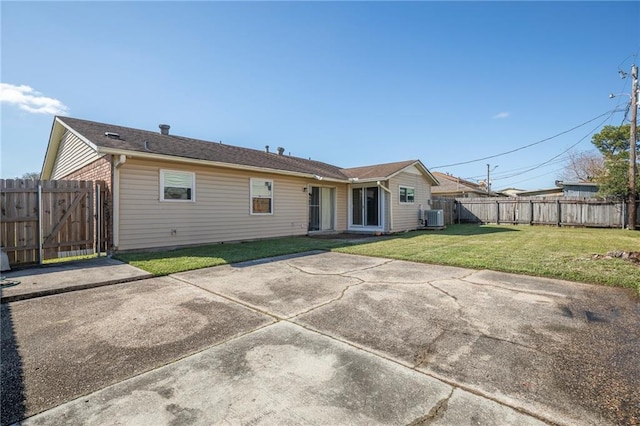 back of house featuring a yard, central AC unit, and a patio area