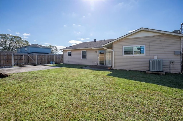 rear view of property featuring cooling unit, a yard, and a patio area