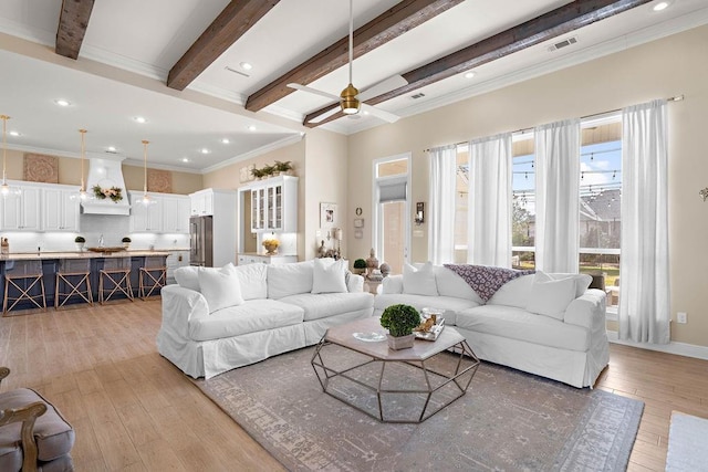 living room with beam ceiling, ceiling fan, light wood-type flooring, and crown molding