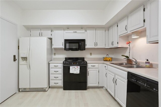 kitchen featuring sink, black appliances, and white cabinetry