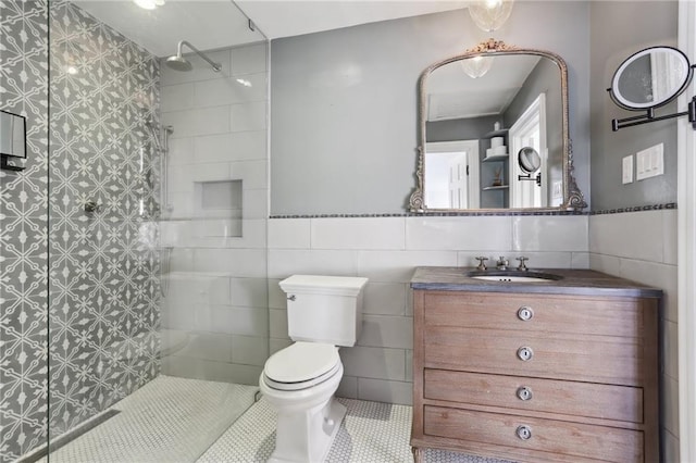 bathroom with tiled shower, tile patterned flooring, tile walls, toilet, and vanity