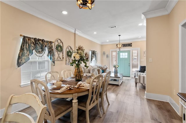 dining space with hardwood / wood-style flooring and crown molding