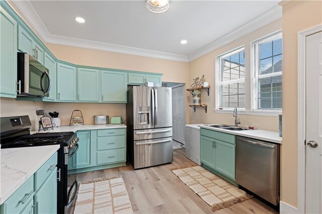 kitchen with appliances with stainless steel finishes, light hardwood / wood-style floors, crown molding, and sink