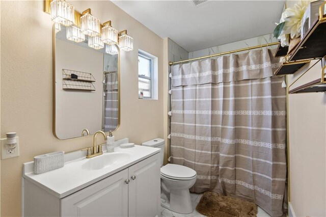 bathroom featuring toilet, vanity, and walk in shower