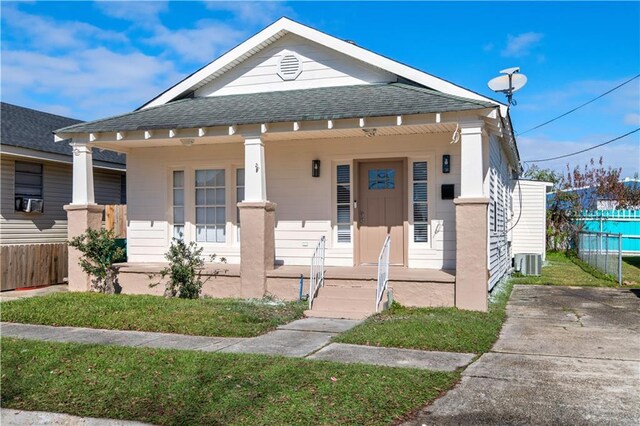 bungalow-style home with covered porch and central air condition unit