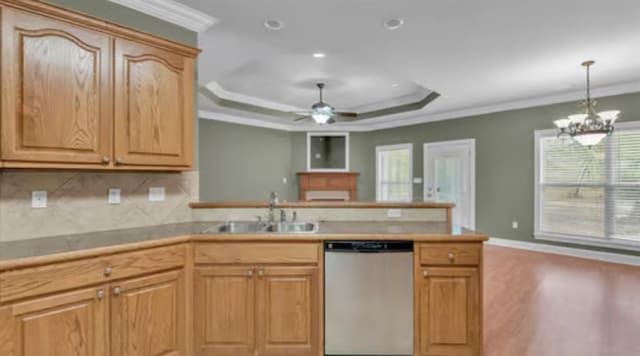 kitchen featuring sink, dishwasher, a raised ceiling, ceiling fan with notable chandelier, and crown molding