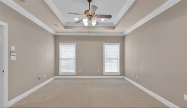 empty room featuring ceiling fan, ornamental molding, and a raised ceiling