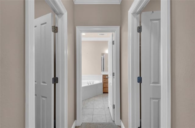 corridor with crown molding and light tile patterned floors