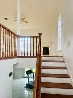 stairs featuring ceiling fan