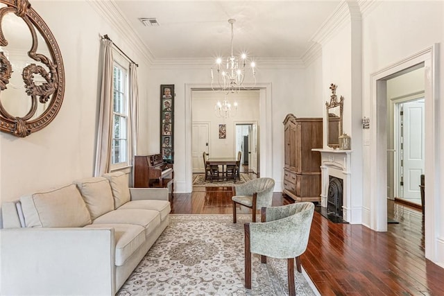 living room featuring dark hardwood / wood-style flooring, ornamental molding, and a chandelier