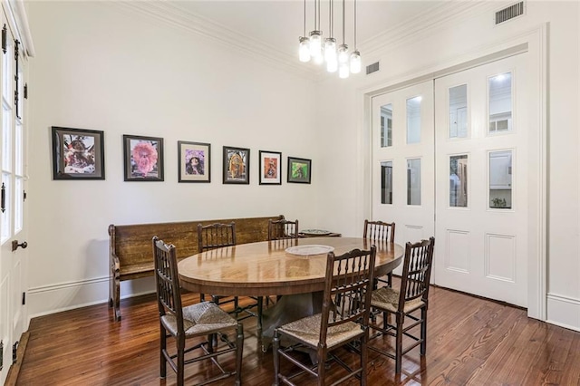 dining room with crown molding and dark hardwood / wood-style flooring