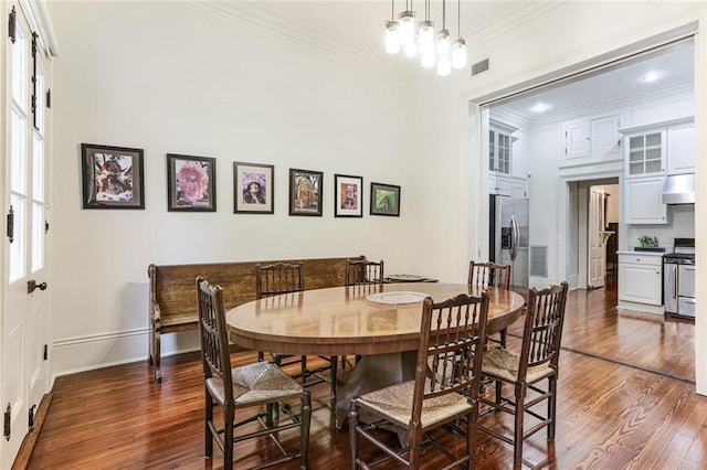 dining room featuring crown molding, dark hardwood / wood-style flooring, and a notable chandelier