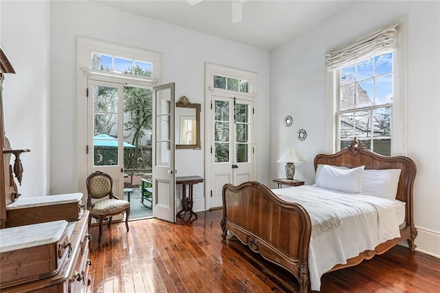 bedroom featuring dark hardwood / wood-style flooring, multiple windows, and ceiling fan