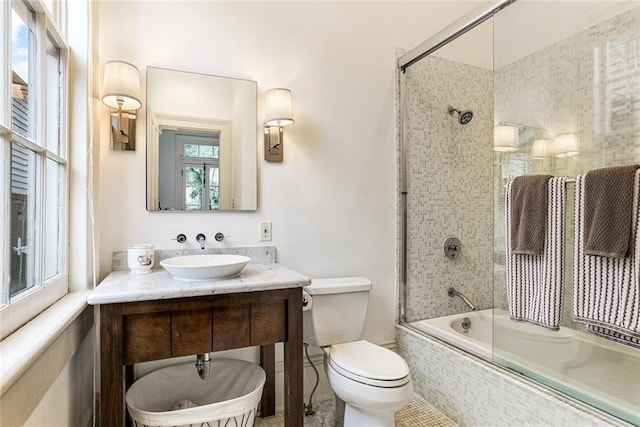 full bathroom with toilet, vanity, and bath / shower combo with glass door