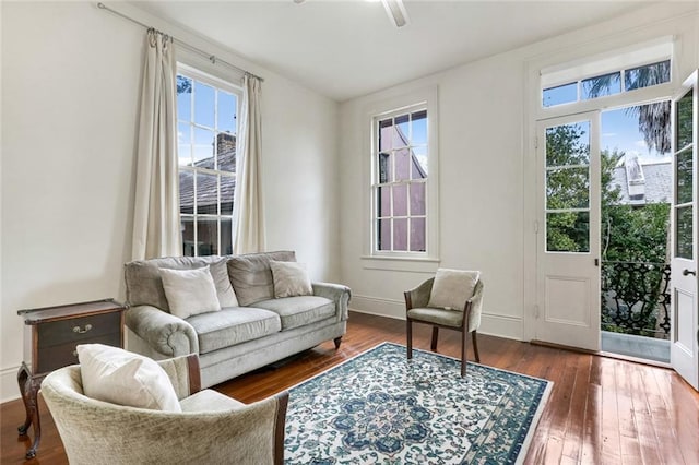 living area featuring dark wood-type flooring and ceiling fan