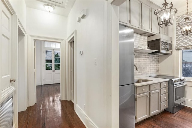 kitchen featuring stainless steel appliances, decorative light fixtures, dark hardwood / wood-style flooring, and decorative backsplash