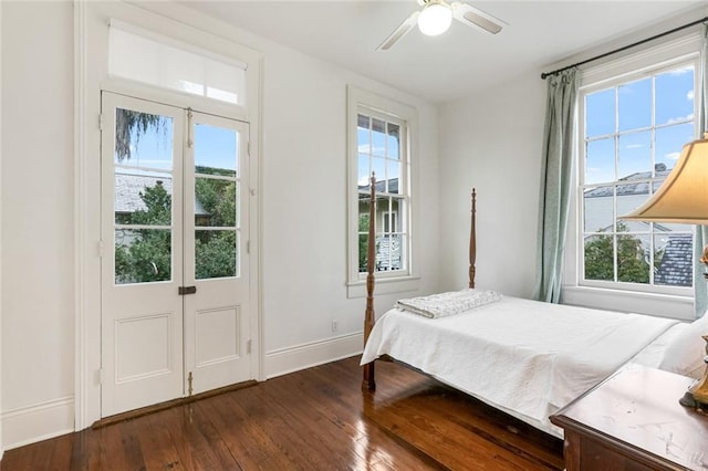 bedroom featuring dark hardwood / wood-style flooring, a water view, and ceiling fan