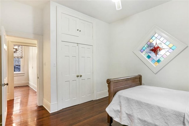 bedroom featuring dark wood-type flooring, ceiling fan, and a closet