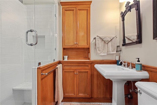 bathroom with toilet and a shower with door