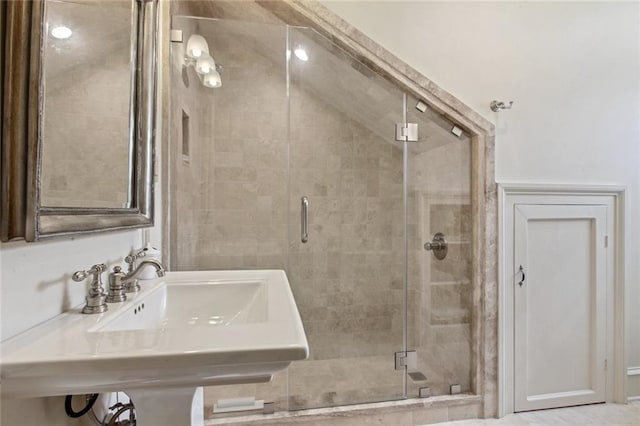 bathroom featuring sink and a shower with door