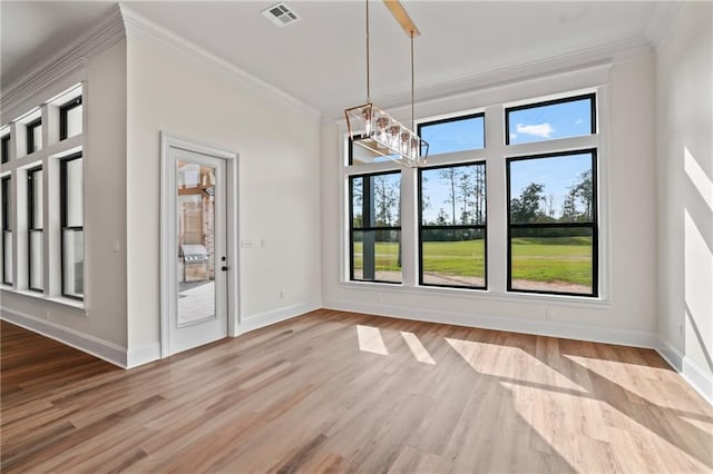 unfurnished dining area featuring crown molding, an inviting chandelier, and light hardwood / wood-style floors