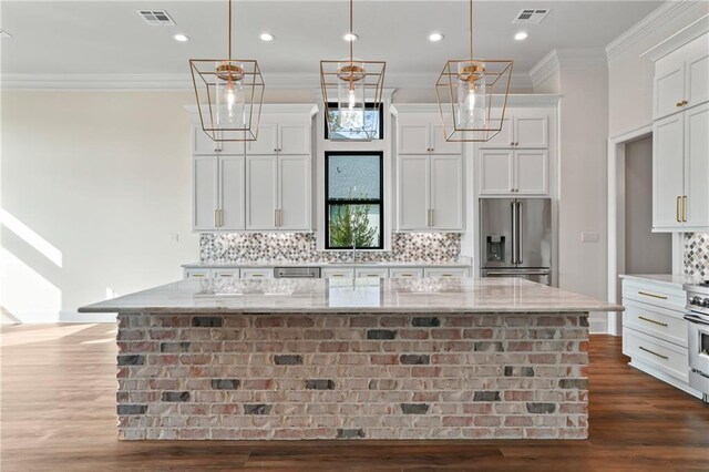 kitchen with high end appliances, light stone countertops, a large island, and pendant lighting