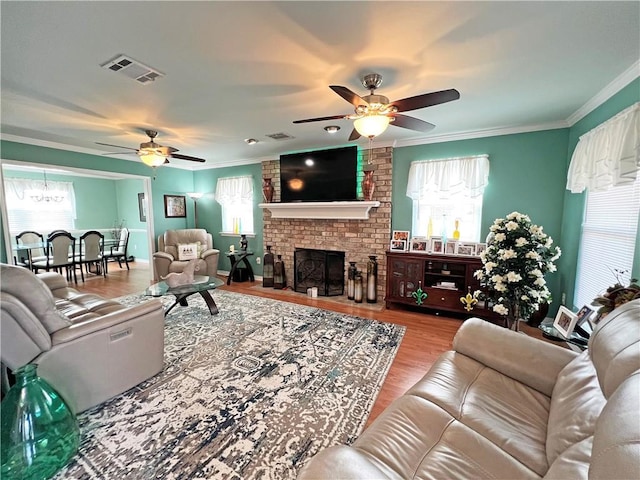 living room featuring ceiling fan, a brick fireplace, a wealth of natural light, and hardwood / wood-style flooring