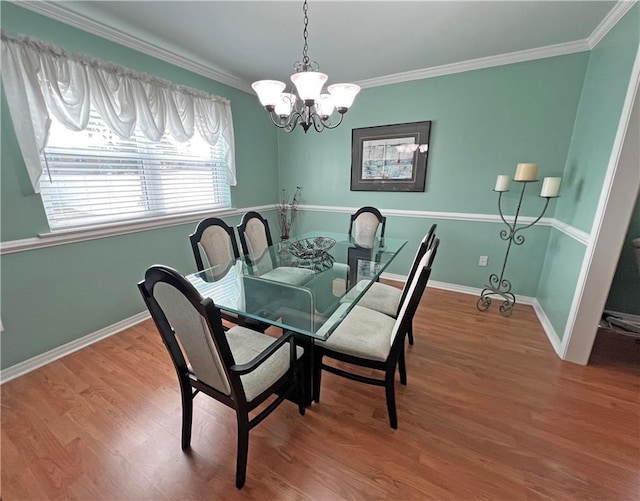 dining space with a notable chandelier, hardwood / wood-style floors, and crown molding