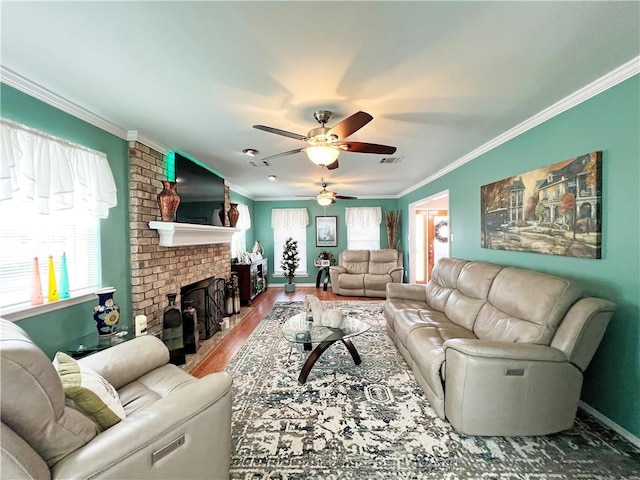 living room with a brick fireplace, ceiling fan, crown molding, and wood-type flooring