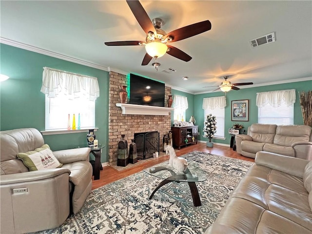 living room featuring ceiling fan, light wood-type flooring, plenty of natural light, and a fireplace