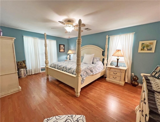 bedroom featuring multiple windows, ceiling fan, and light wood-type flooring