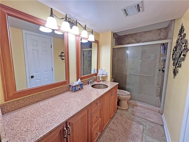 bathroom featuring toilet, a shower with door, a textured ceiling, and vanity