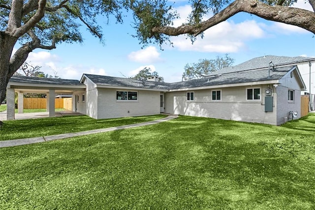 rear view of property featuring a yard and a carport