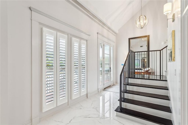 entrance foyer featuring lofted ceiling, a wealth of natural light, and a chandelier