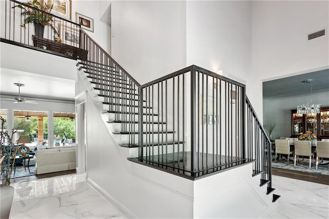 112 Bayou Perez Dr, Madisonville, LA 70447 - stairway featuring a towering ceiling, marble tiled floors, a chandelier, and ceiling fan