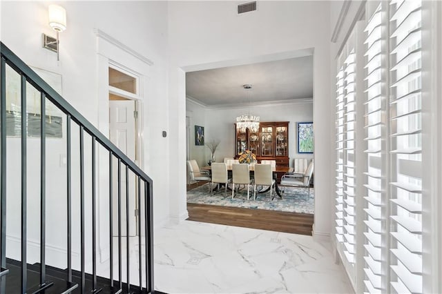 112 Bayou Perez Dr, Madisonville, LA 70447 - foyer entrance featuring marble tiled flooring, a chandelier, crown molding, and baseboards