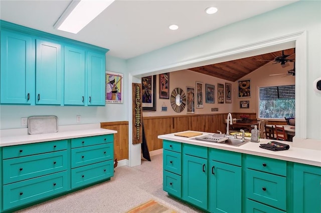 112 Bayou Perez Dr, Madisonville, LA 70447 - kitchen featuring a sink, a wainscoted wall, vaulted ceiling, light countertops, and wooden walls