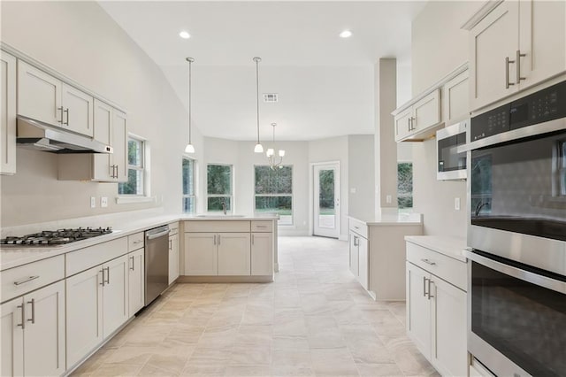 kitchen featuring kitchen peninsula, stainless steel appliances, an inviting chandelier, and hanging light fixtures