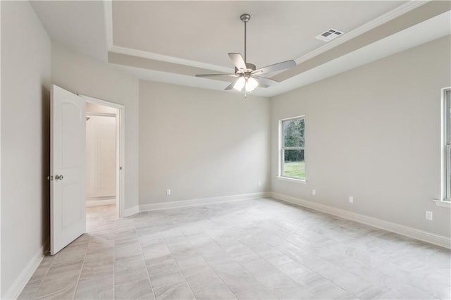 empty room featuring ceiling fan and a raised ceiling