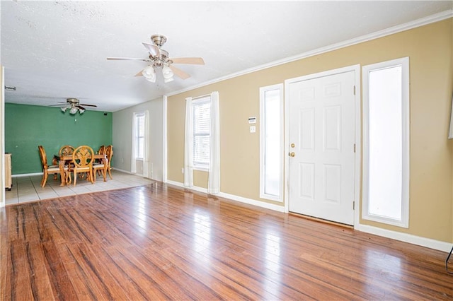 foyer with ceiling fan, light hardwood / wood-style flooring, and crown molding