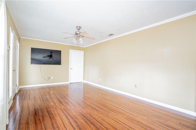 spare room featuring wood-type flooring, ceiling fan, and crown molding