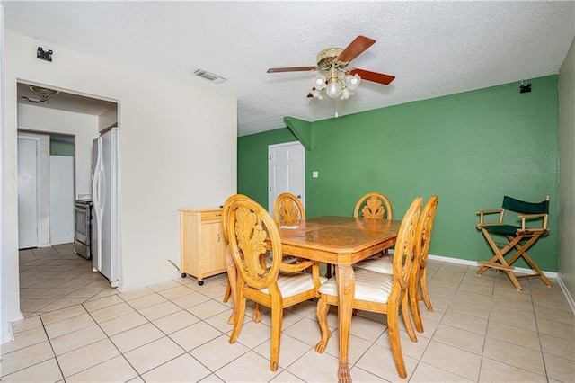 tiled dining room featuring a textured ceiling and ceiling fan