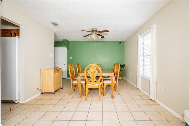 dining area with a textured ceiling, ceiling fan, and light tile patterned floors