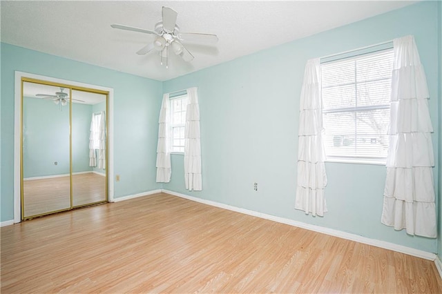 unfurnished room with ceiling fan, light hardwood / wood-style floors, and a wealth of natural light