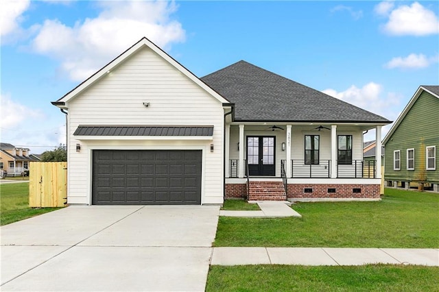 view of front of home with a front yard, a garage, and covered porch