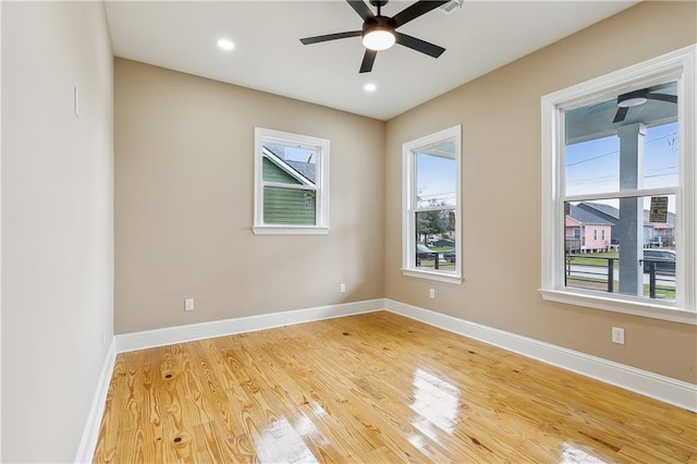 unfurnished room featuring ceiling fan, a wealth of natural light, and wood-type flooring