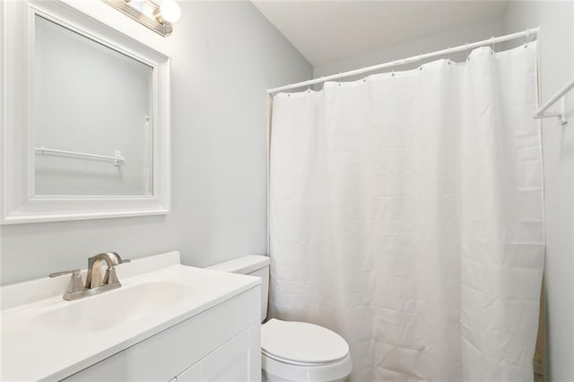 bathroom with walk in shower, vanity, and toilet