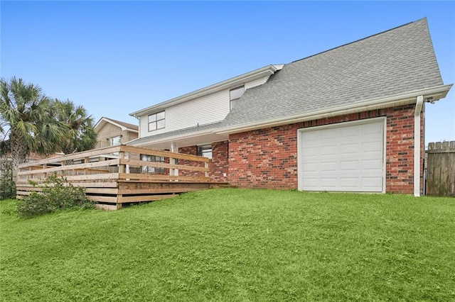 back of property featuring a lawn, a garage, and a wooden deck